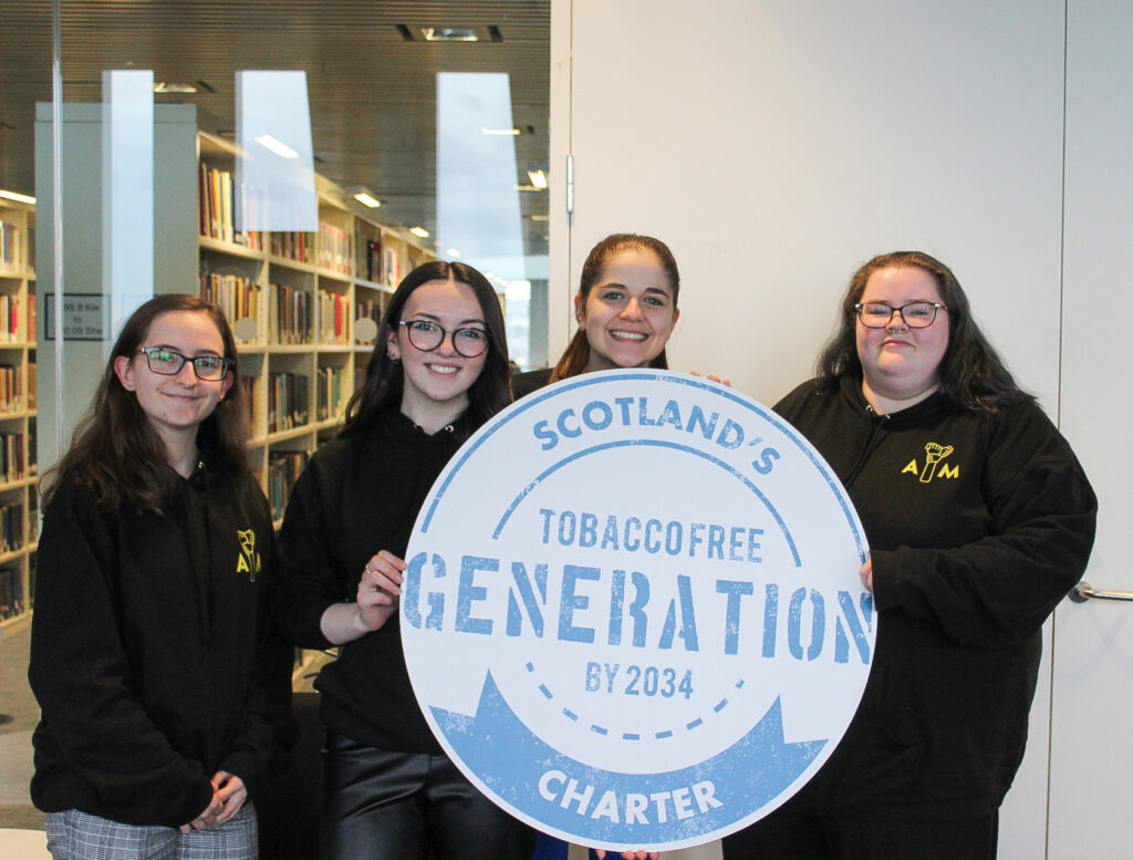 The image shows Aberdeen Youth Movement representatives Hannah Forbes, Rebecca MacDonald, Lily Macdonald and Samantha Milne with ASH Scotland’s Charter for a Tobacco-free Generation.